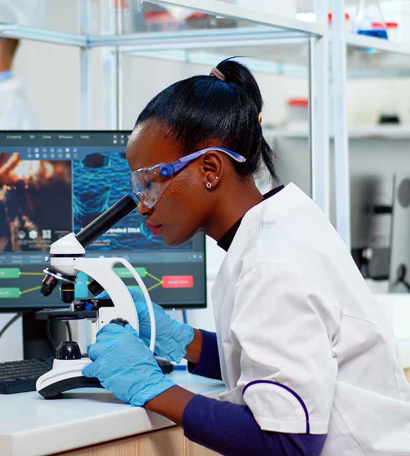 Female scientist in a lab looking into a microscope
