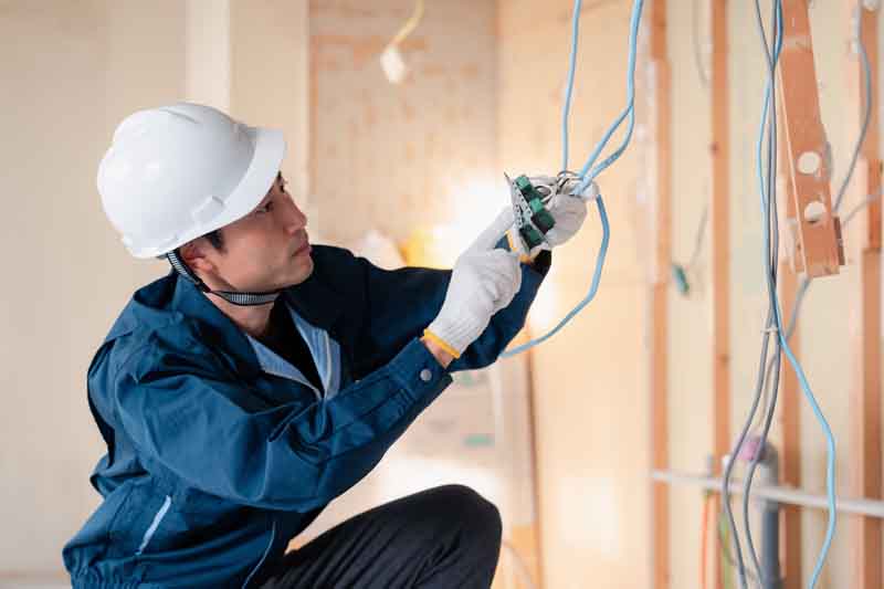 Electrician installing an electric outlet on a new house