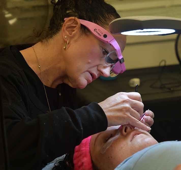eyelash technician working on a client's eyelashes