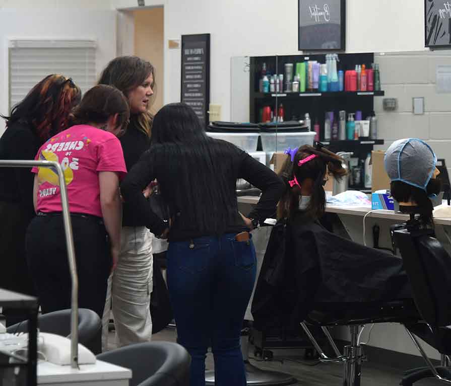 students huddled together in the beauty salon