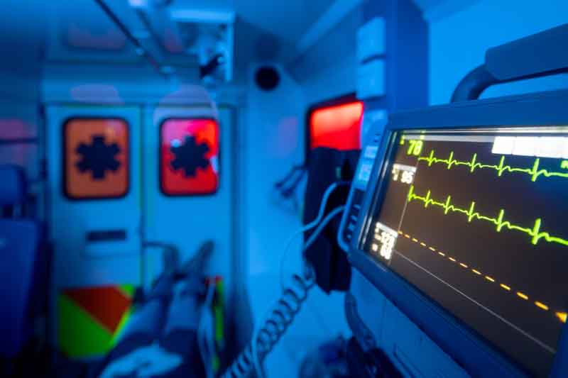 Inside the back of an ambulance with a heart monitor in the foreground