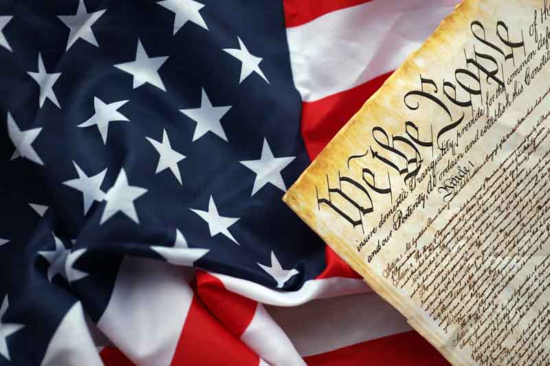 The U.S. constitution resting on top of an American flag