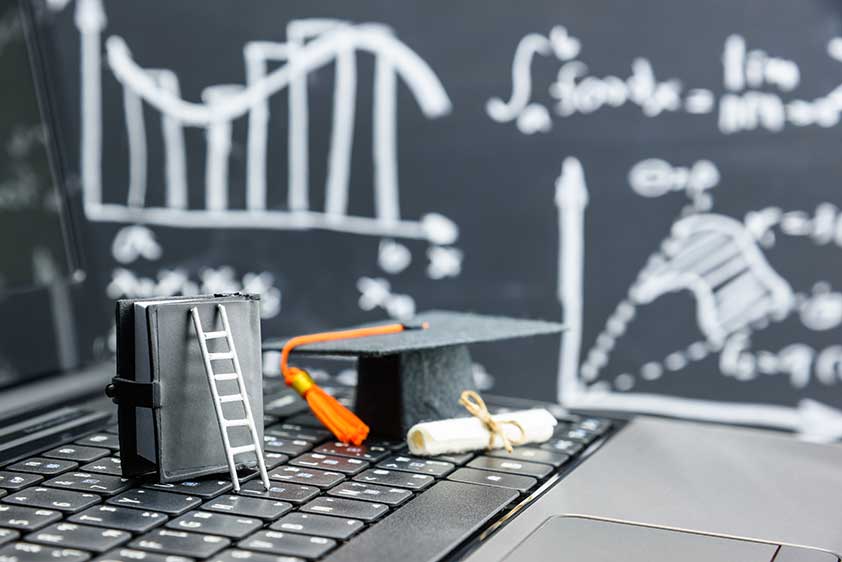 graduation hat next to statistics on a chalkboard