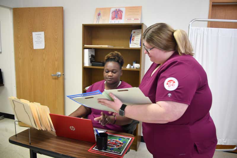 two female nurses handling patient documents