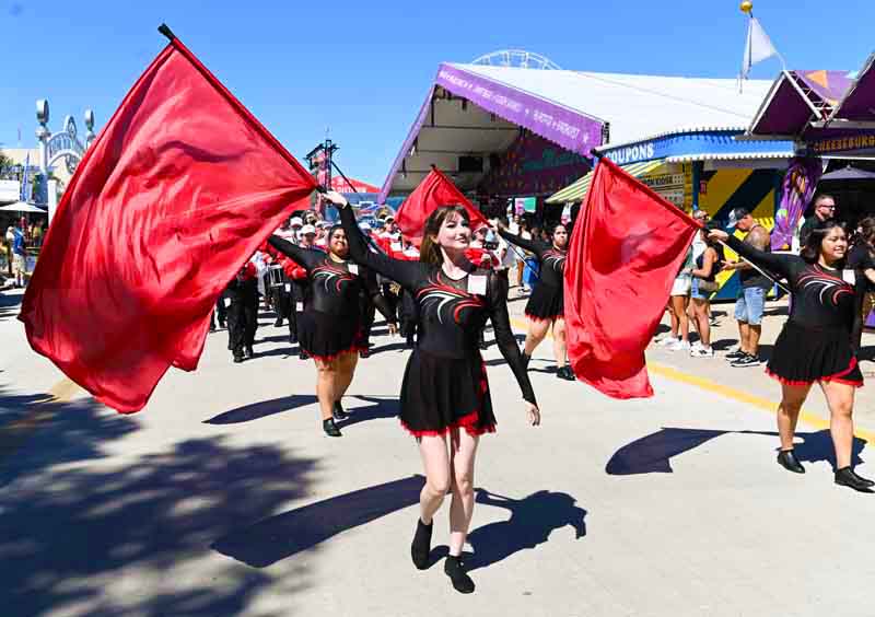 Flag girls walking with marching band