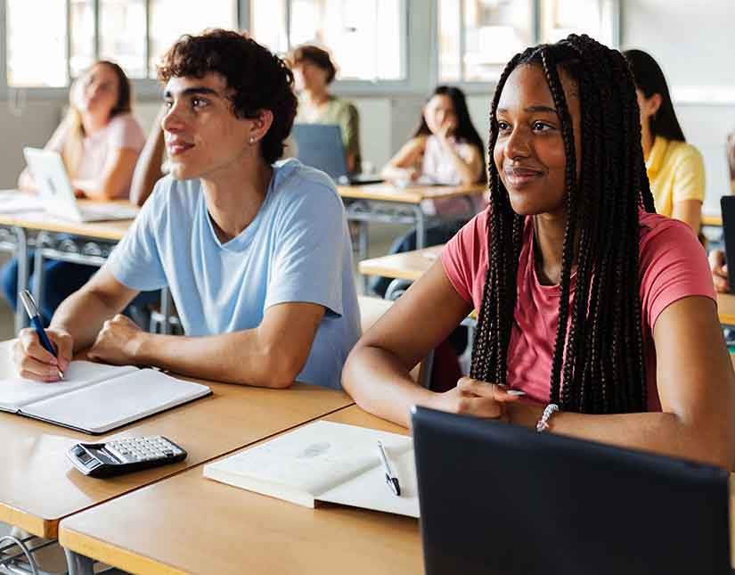 High school students in a classroom attentively listening to the teacher